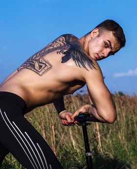 Sexy guy with tattoos in tight spandex pants
