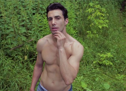 Sexy guy in jeans poses front and back outdoor